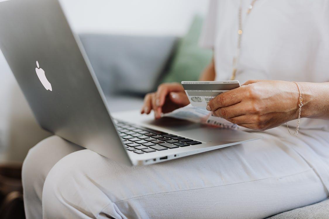 A person is entering their credit card details into the laptop