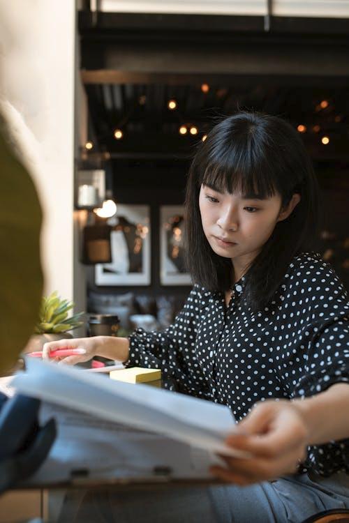 An individual reviewing medical files and insurance forms.