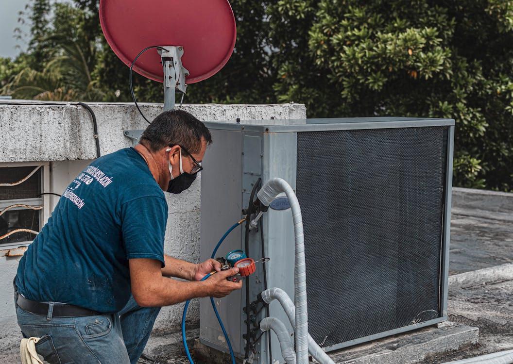 An HVAC contractor inspecting an air conditioning unit