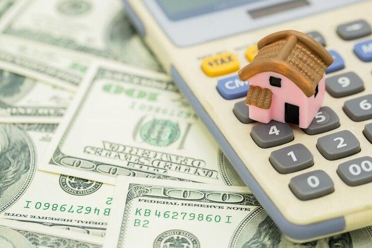 Calculator and house model on a desk