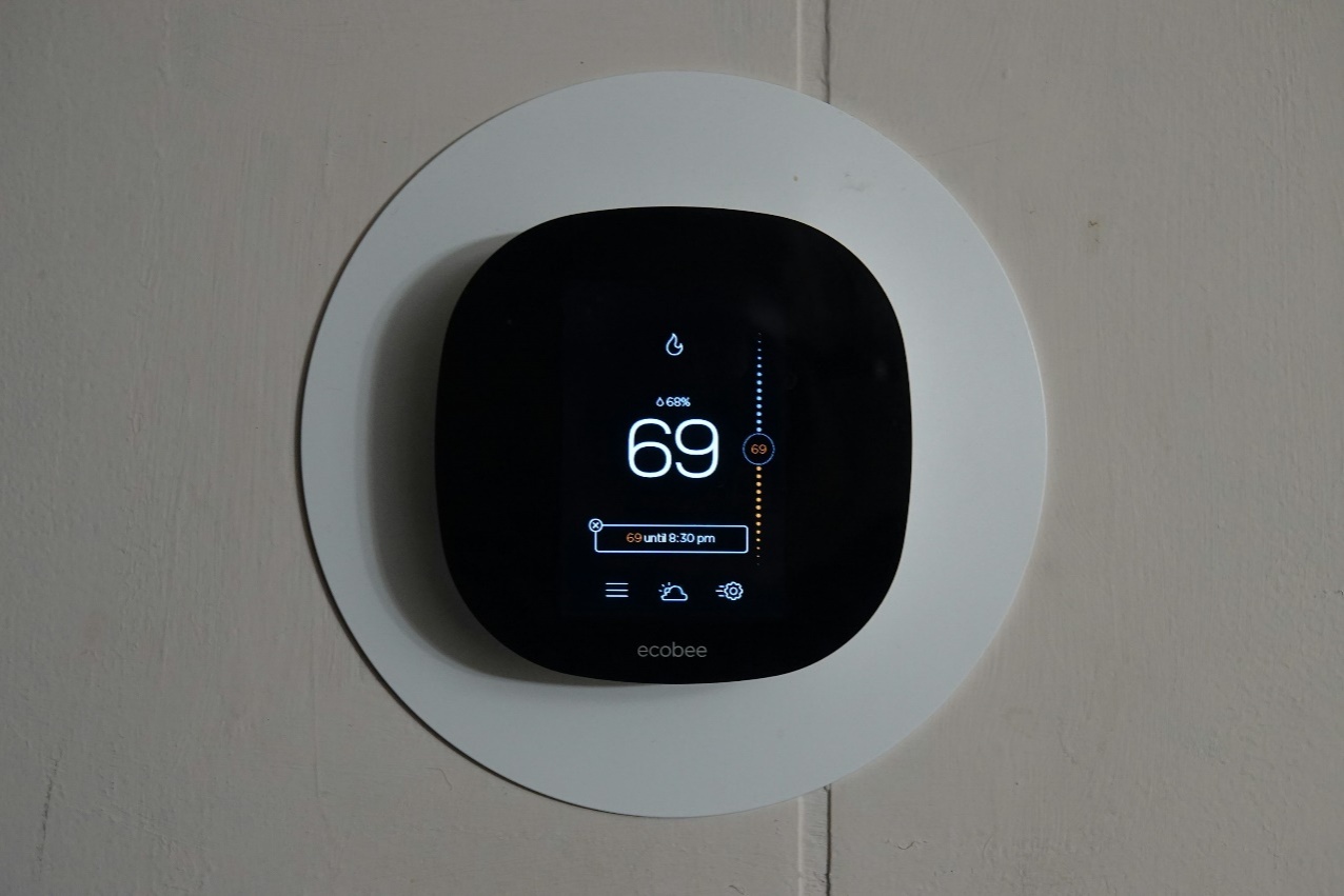 A thermostat on a wall showing 69 reading