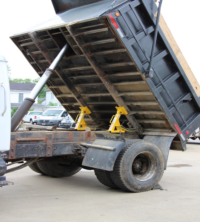 A repair facility using a truck bed lock to secure a dump truck bed.