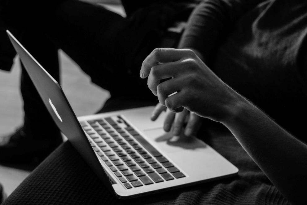 A grayscale image of a person using a computer for therapy.