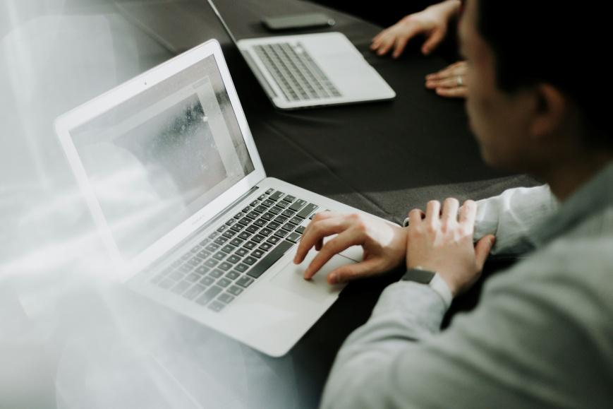 A man sitting in front of a laptop.