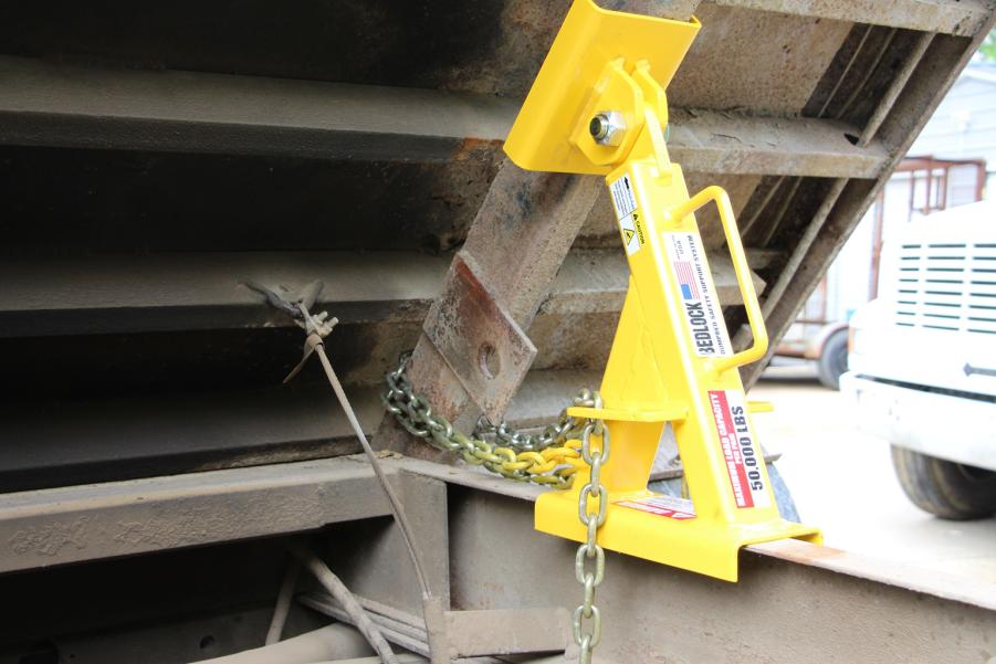 Close-up of a BedLock system securely installed under a raised dump truck bed