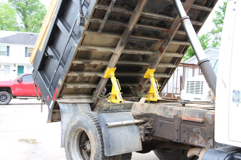 BedLock truck bed lock installed on a dump truck in a professional repair shop