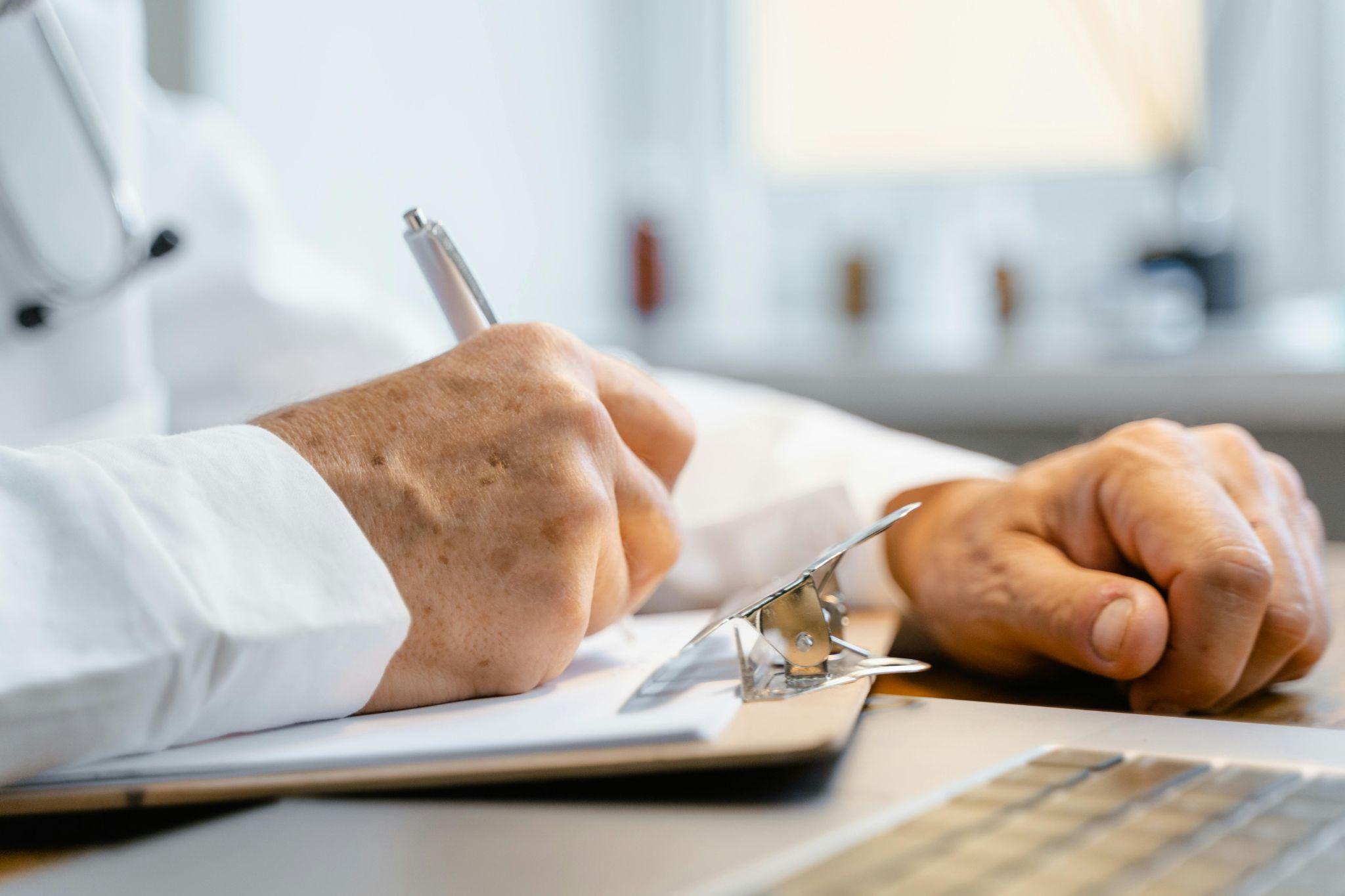 a doctor writing a note with a pen