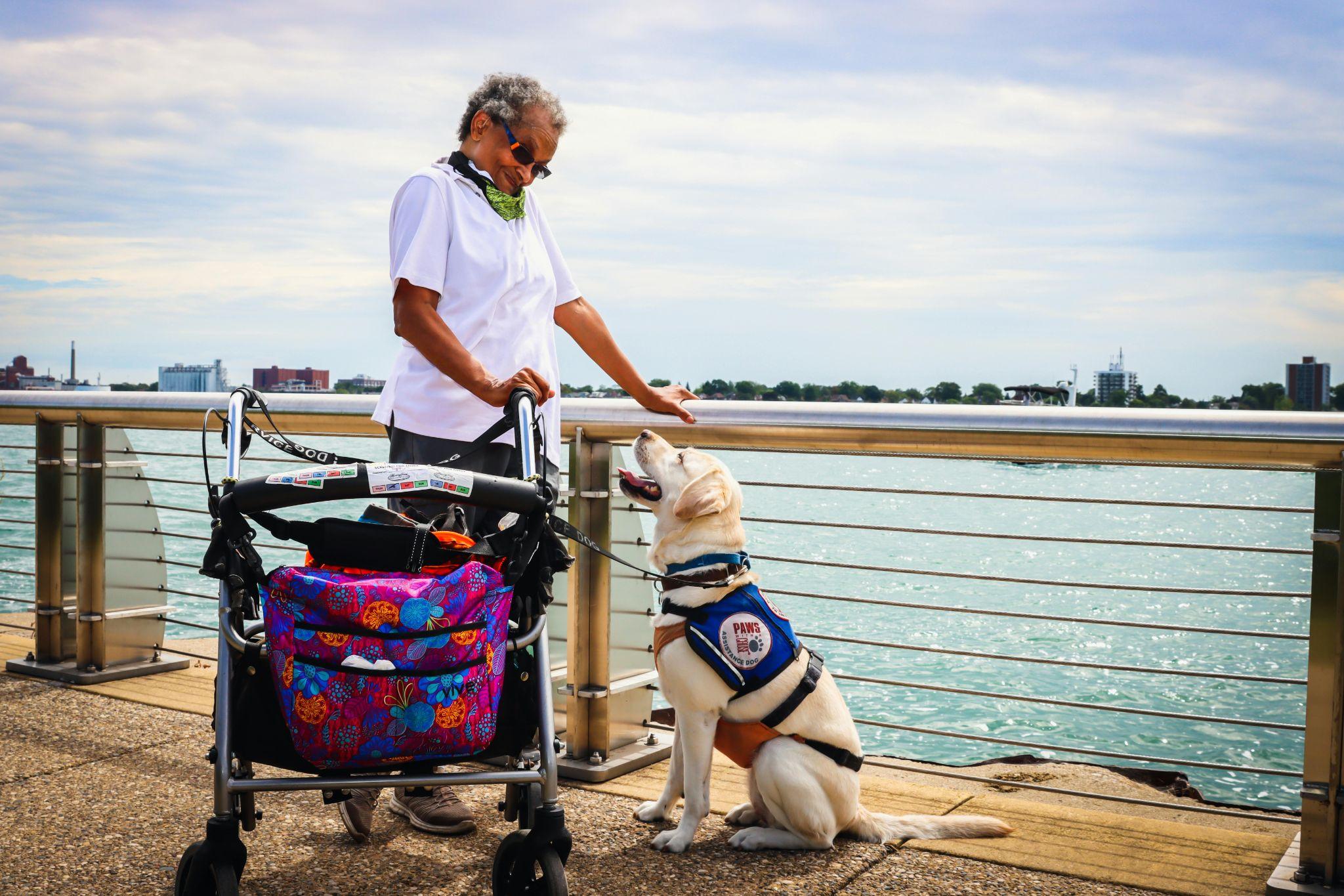 a woman standing with a stroller and an emotional support dog