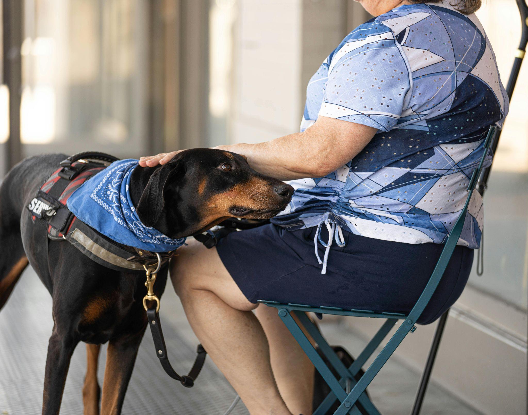 a woman seated with her emotional support dog by her side