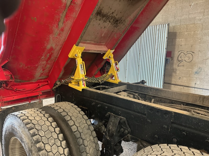 Two BedLock safety devices installed on a raised dump truck bed