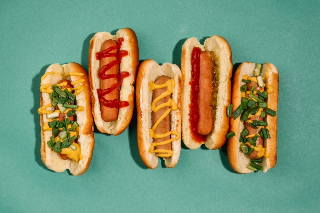 A lineup of colorful artisan hot dogs with creative toppings