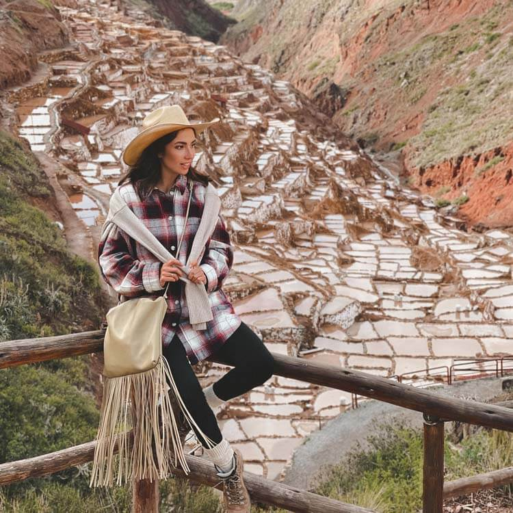 a woman sitting on a ledge at the Sacred Valley