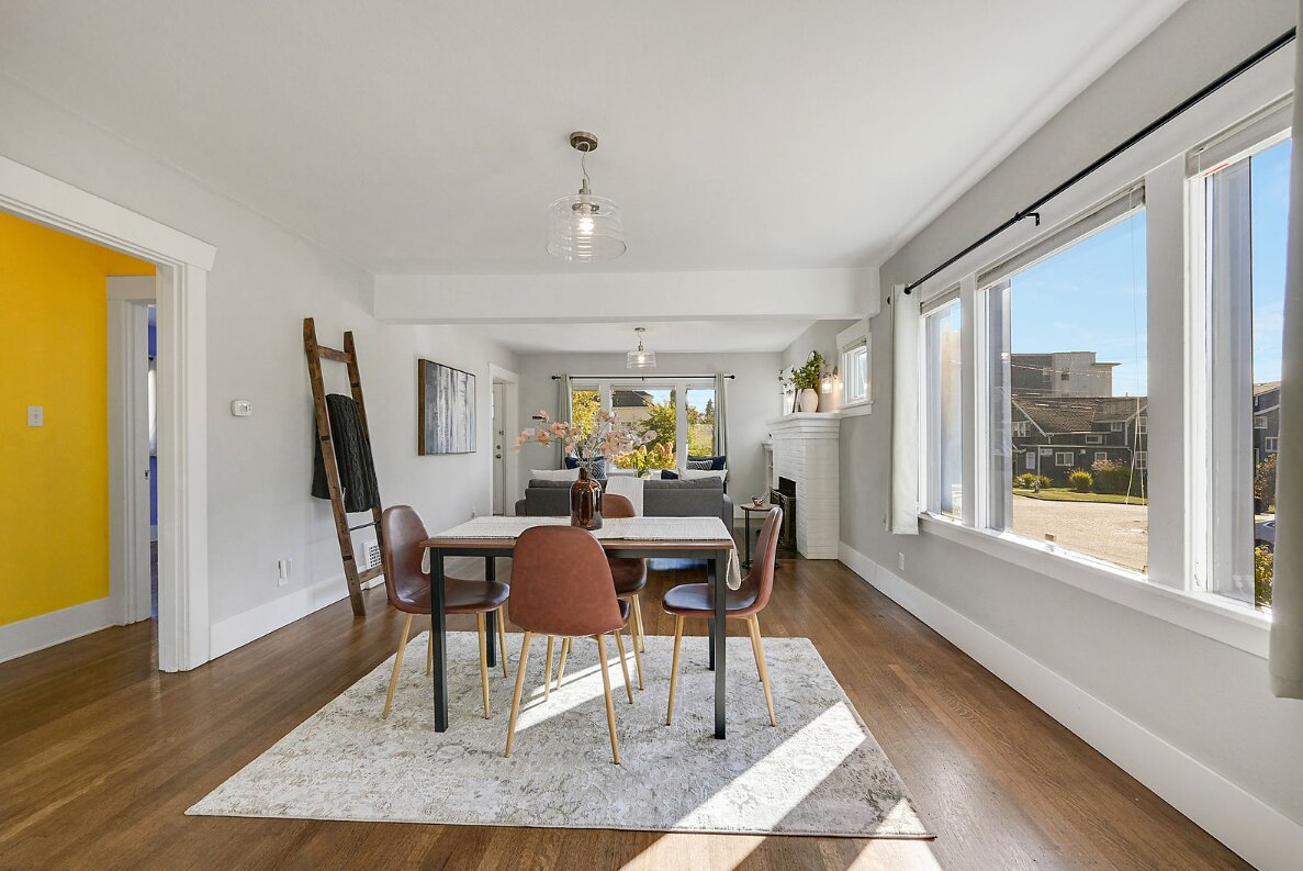 sunlit dining room with large windows and wood floors