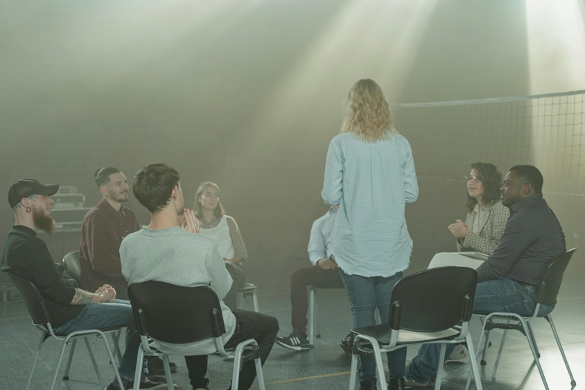 Residential recovery program staff leading a structured group therapy session in a professional setting
