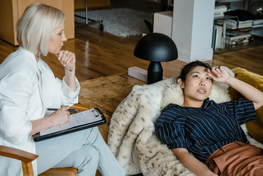 This image shows a woman lying on the couch at a therapy session.